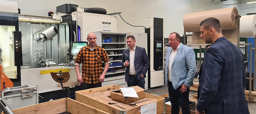 Wicemarszałek województwa Tomasz Sobieraj (w środku) i prezes firmy Inter-Metal Tomasz Maksymiuk (błękitna marynarka) na hali produkcyjnej.